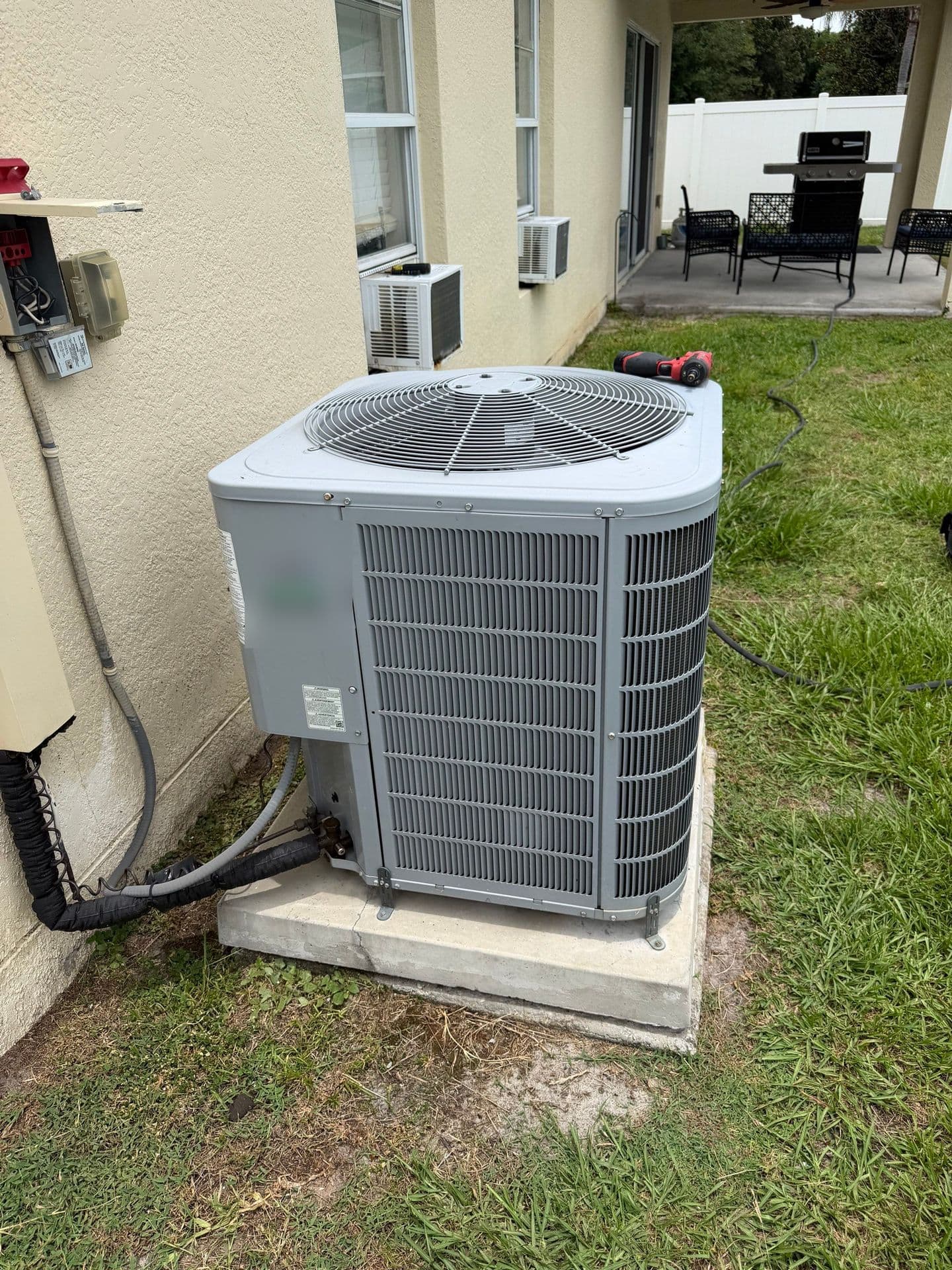 Protek Heating & Cooling technician servicing an AC condenser in Tampa FL