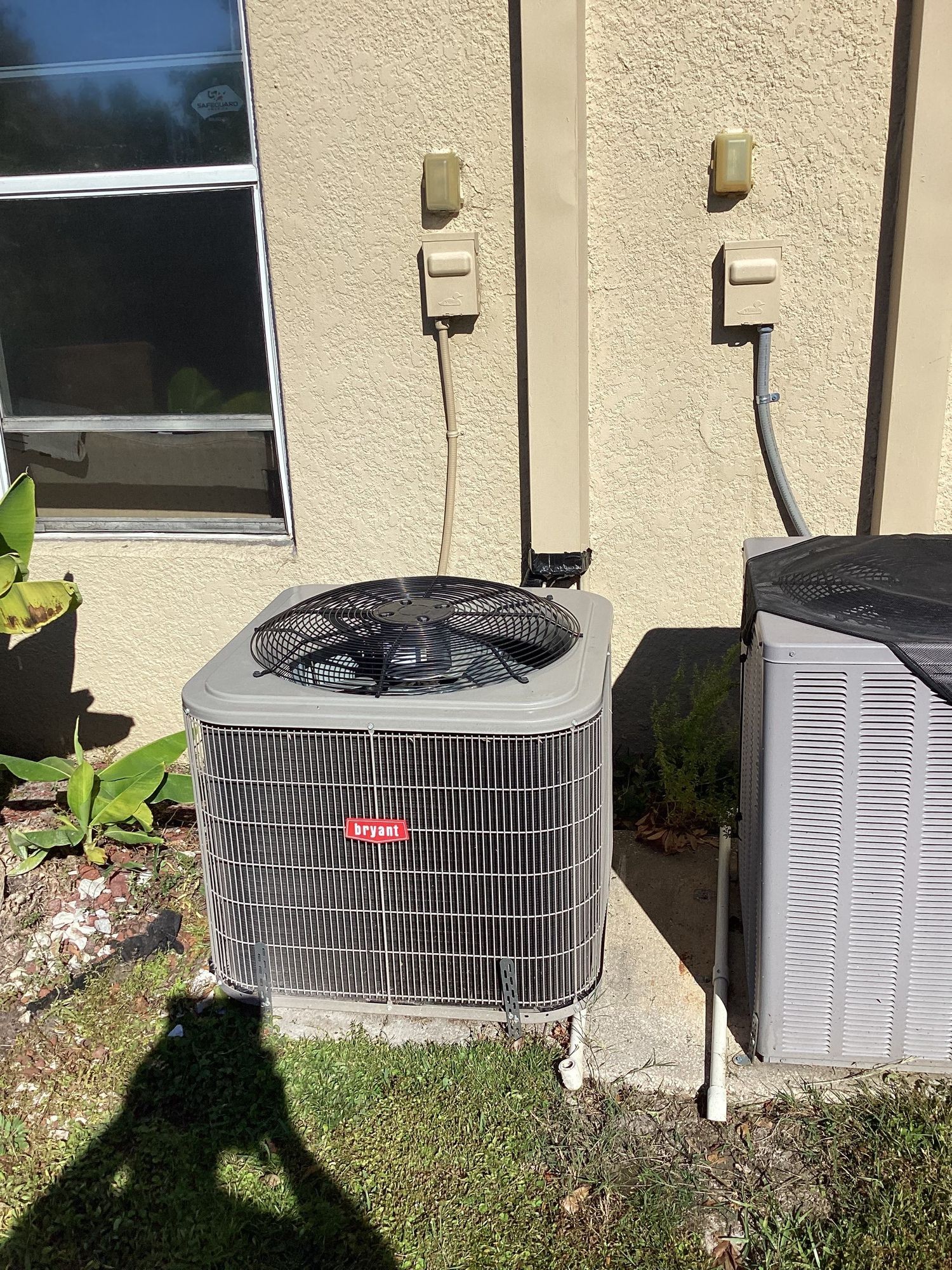 Both outdoor AC units along the exterior wall after the condenser move