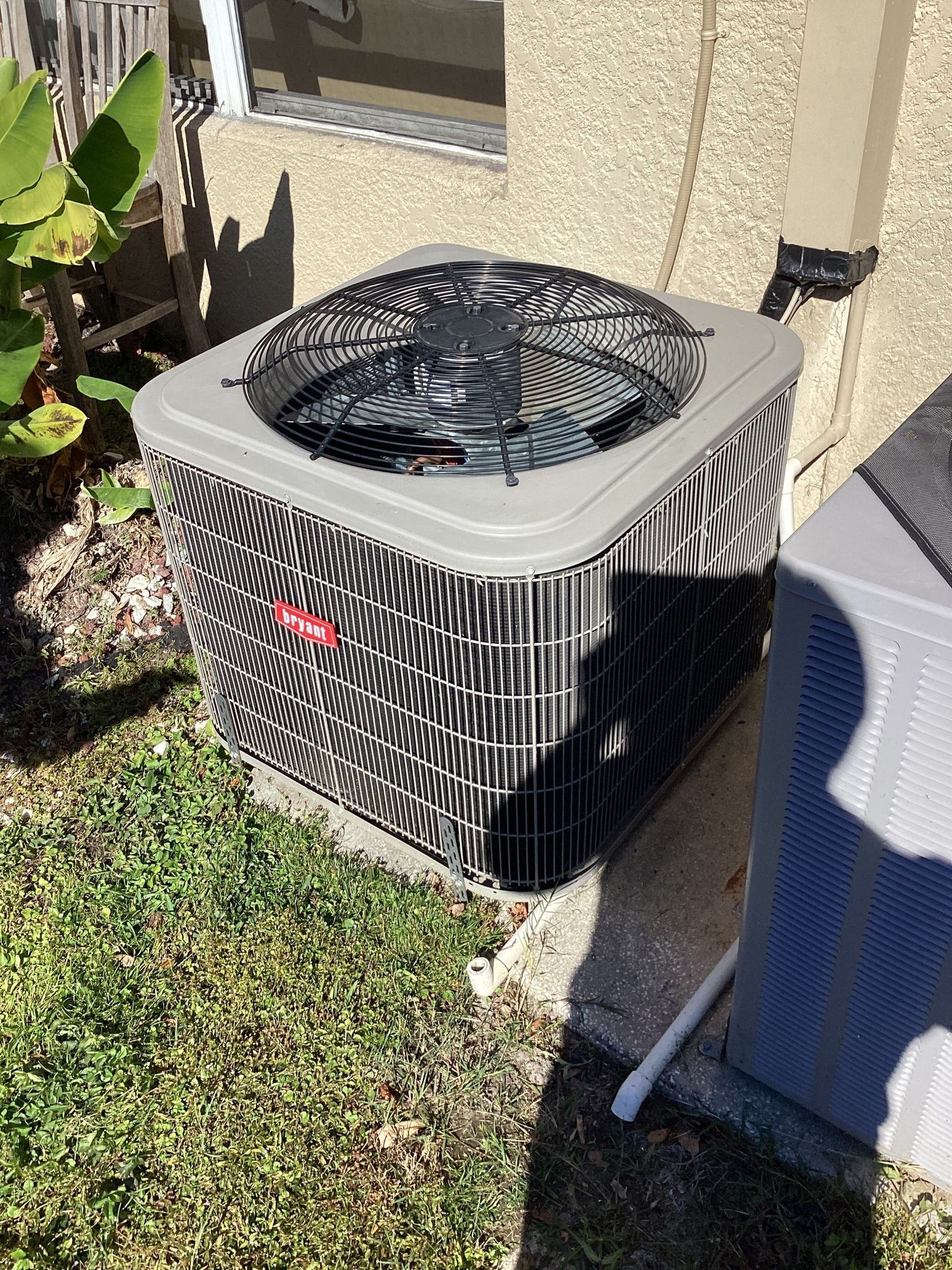 Close-up of the AC condenser leveled on its new pad after relocation