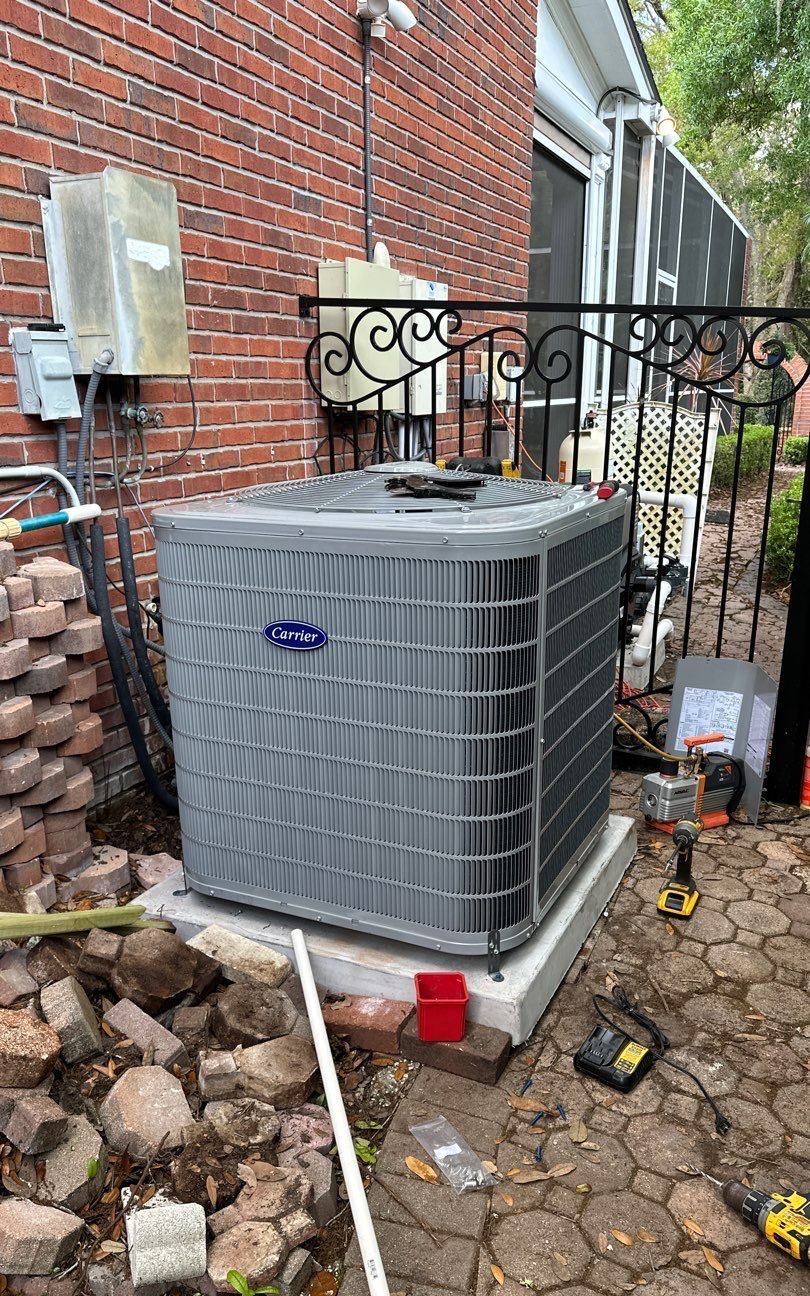 New heat pump outdoor unit on a new pad beside a brick home in New Tampa, FL