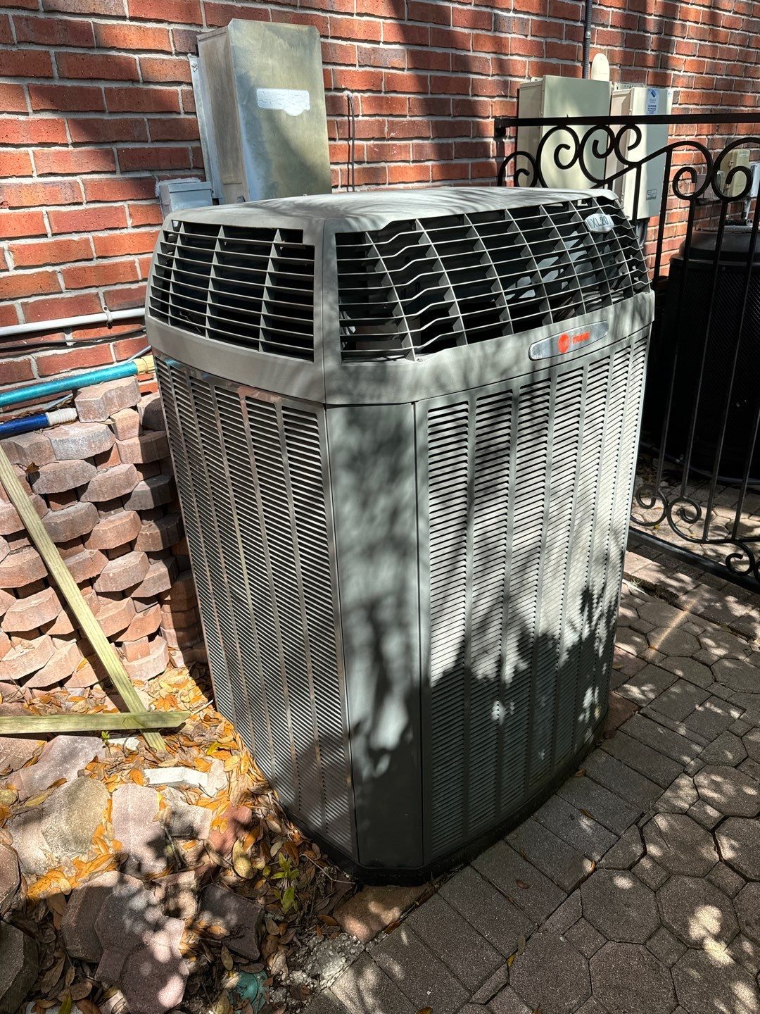 Old outdoor unit beside a New Tampa home before heat pump replacement