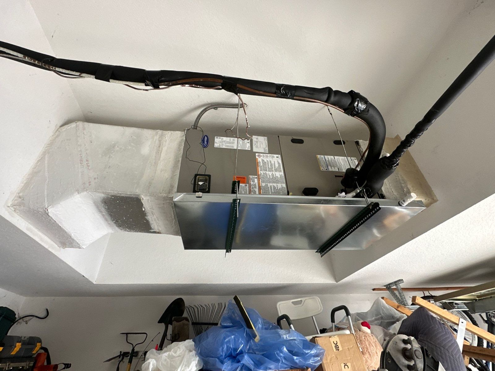 New horizontal air handler hung in a garage alcove with an emergency drain pan