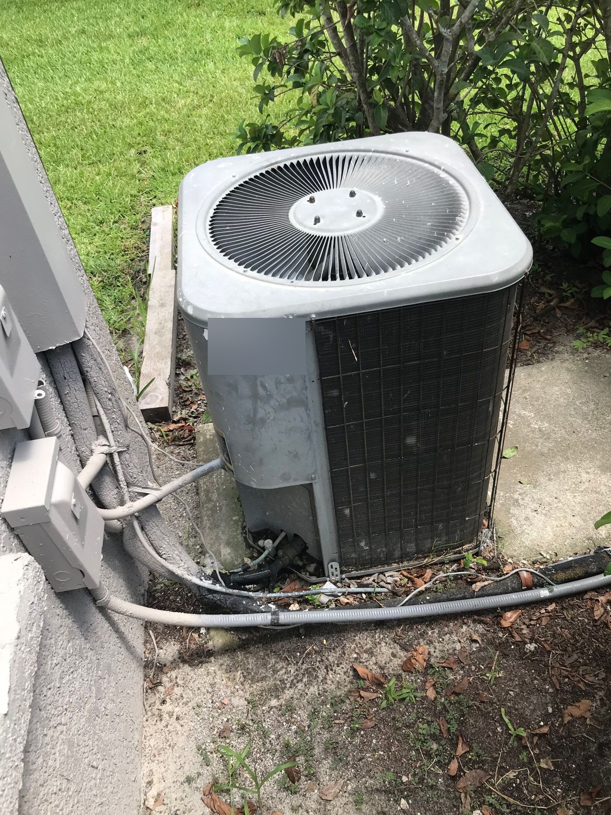 Old outdoor unit beside a Wesley Chapel home before replacement