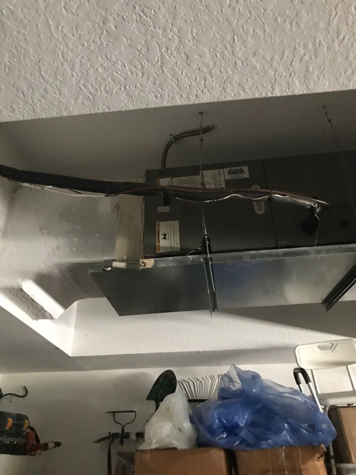 Old horizontal air handler mounted in a garage alcove