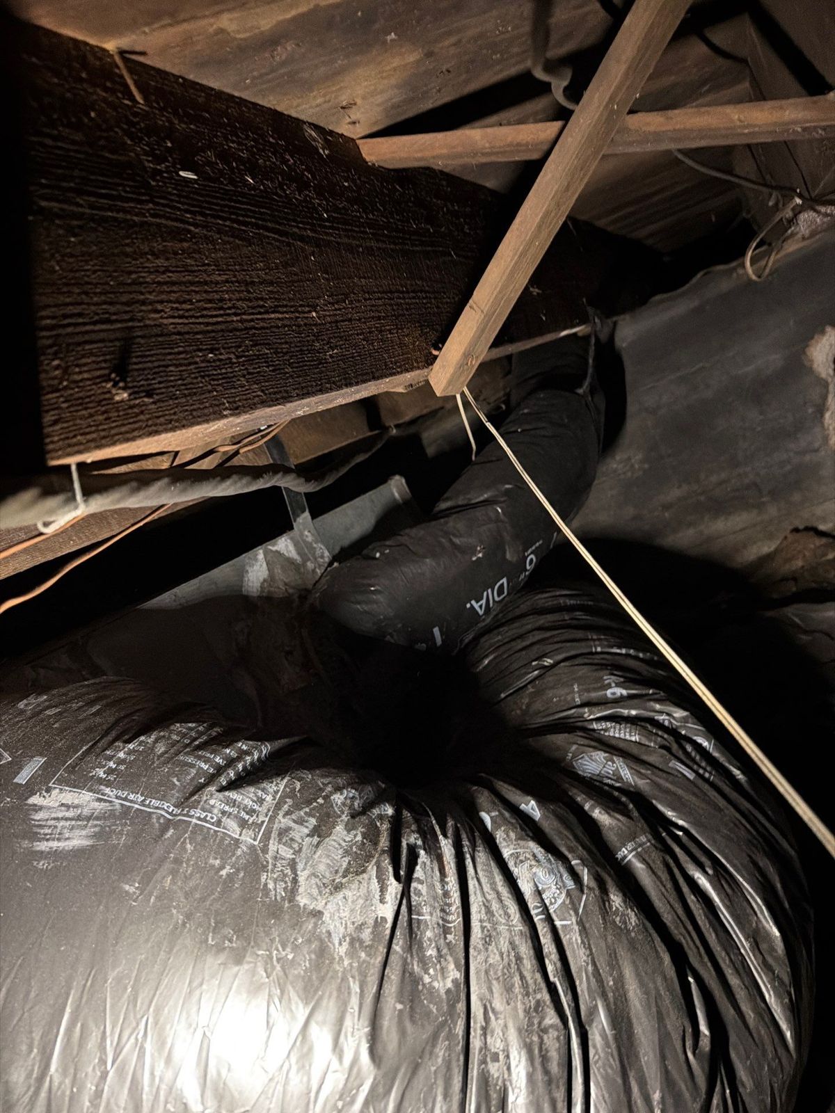 Worn foil-jacketed duct trunk under the floor of a South Tampa home