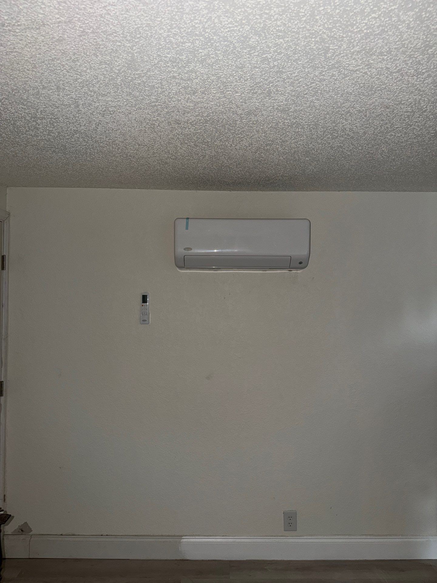 Ductless mini-split head mounted high on the wall of the remodeled living space