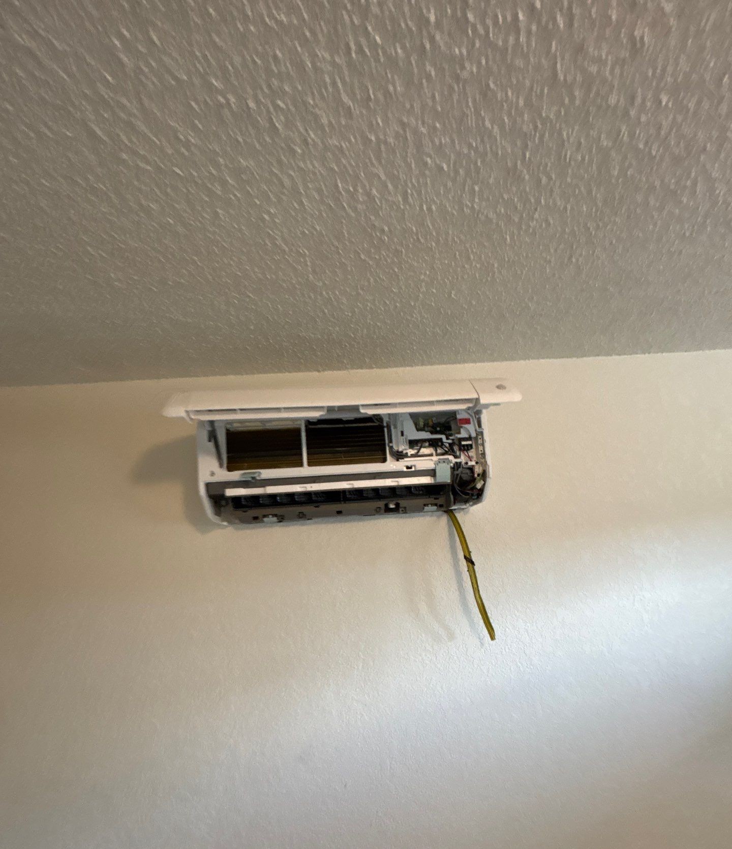 Wall-mounted mini-split indoor head open for wiring during installation