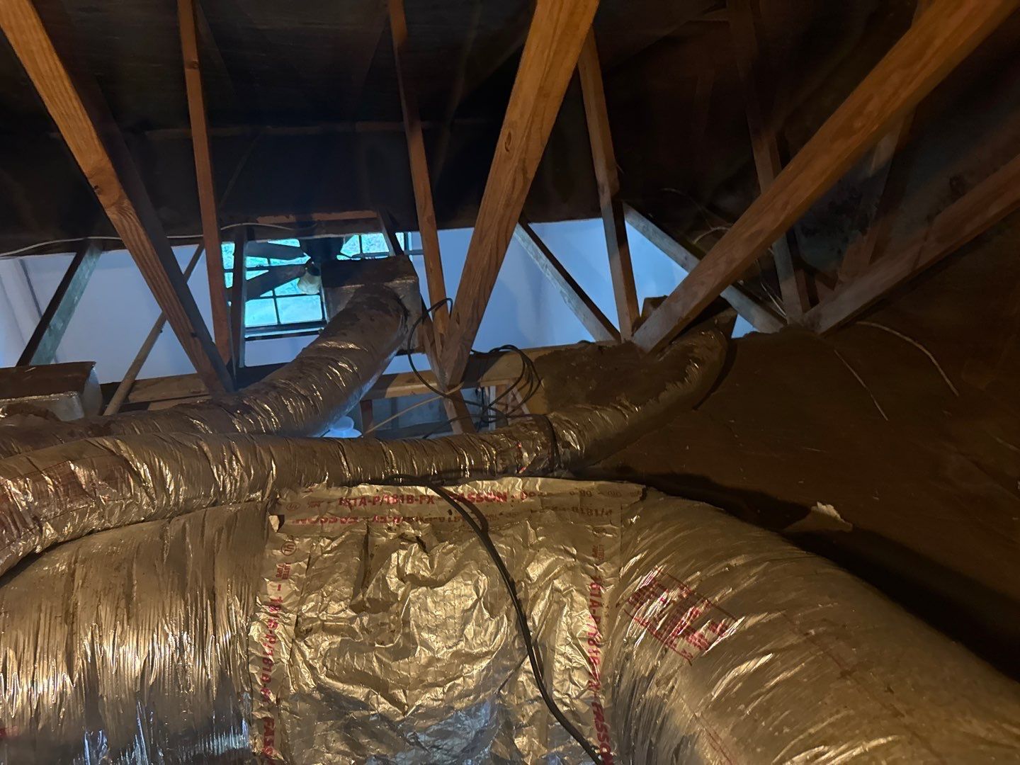 Old worn flex ductwork in the attic before replacement