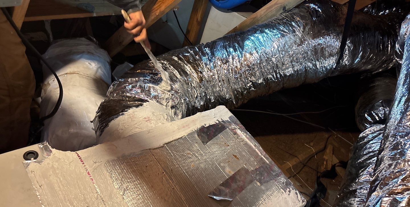 Technician sealing duct connections at the new plenum