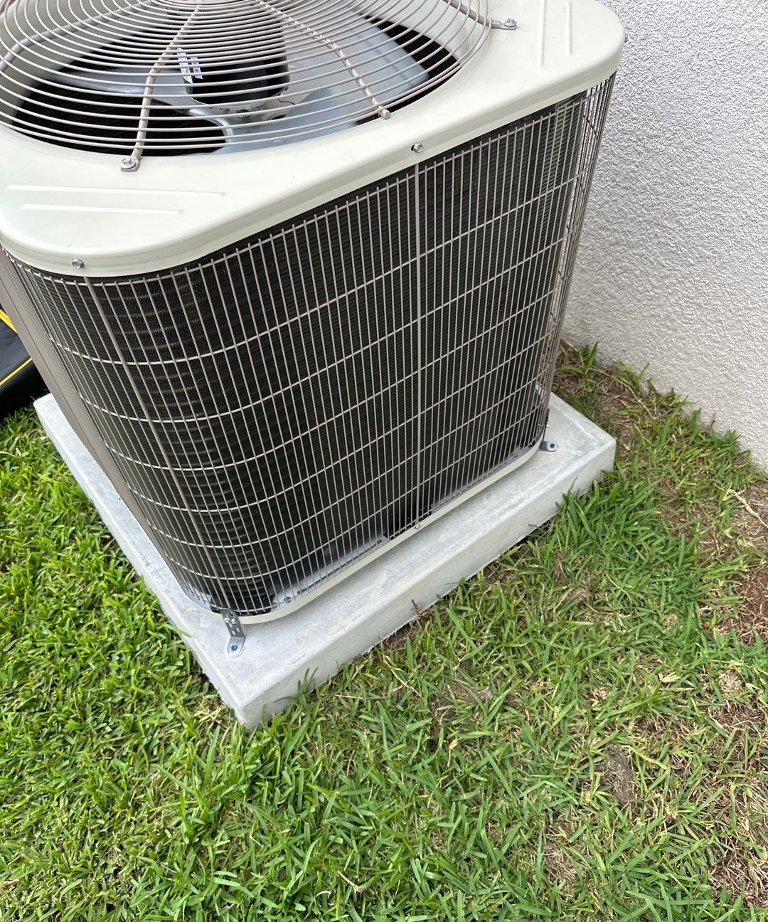 New heat pump outdoor unit on a pad after installation