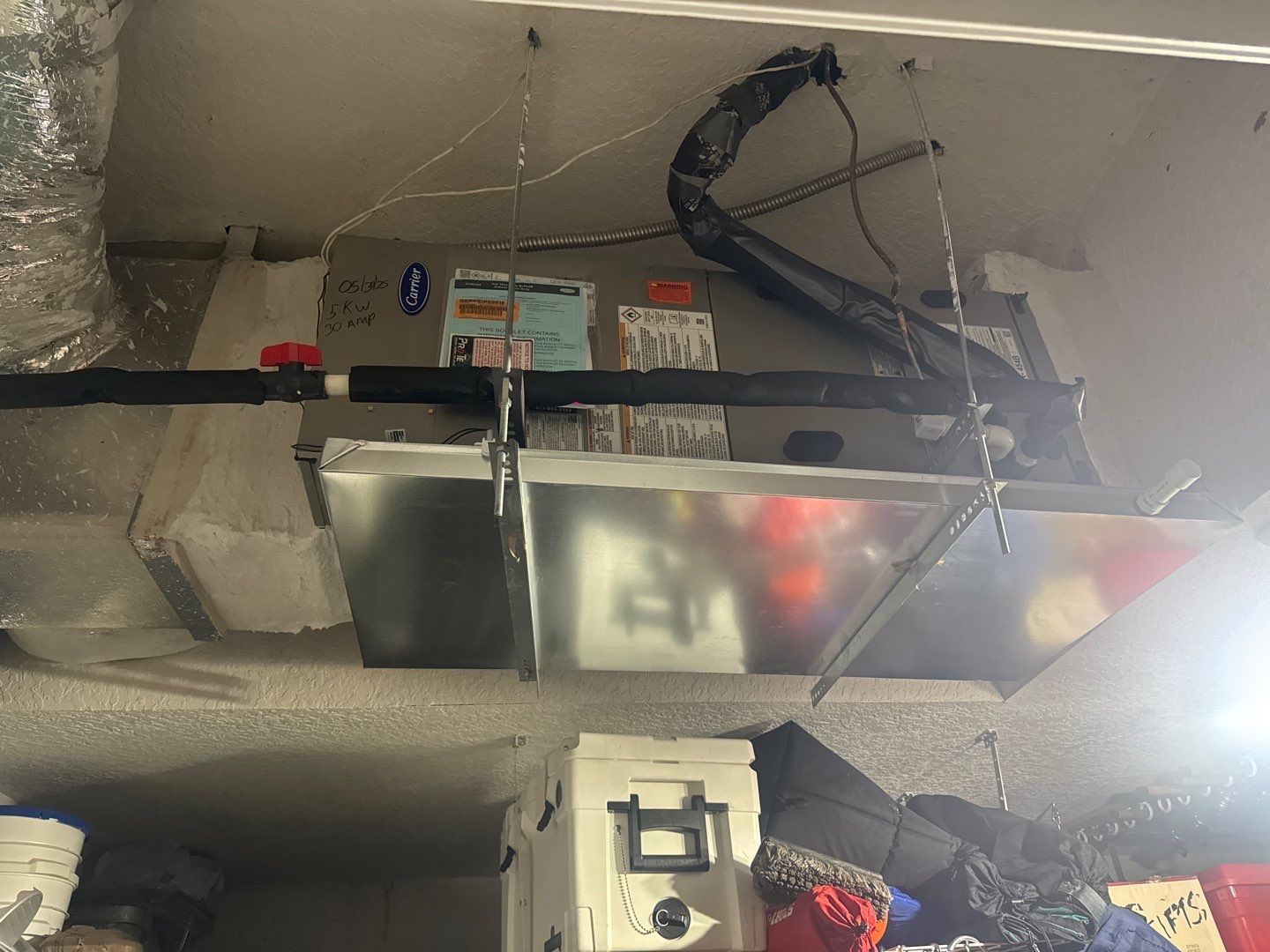 New horizontal air handler hung in a garage with an emergency drain pan