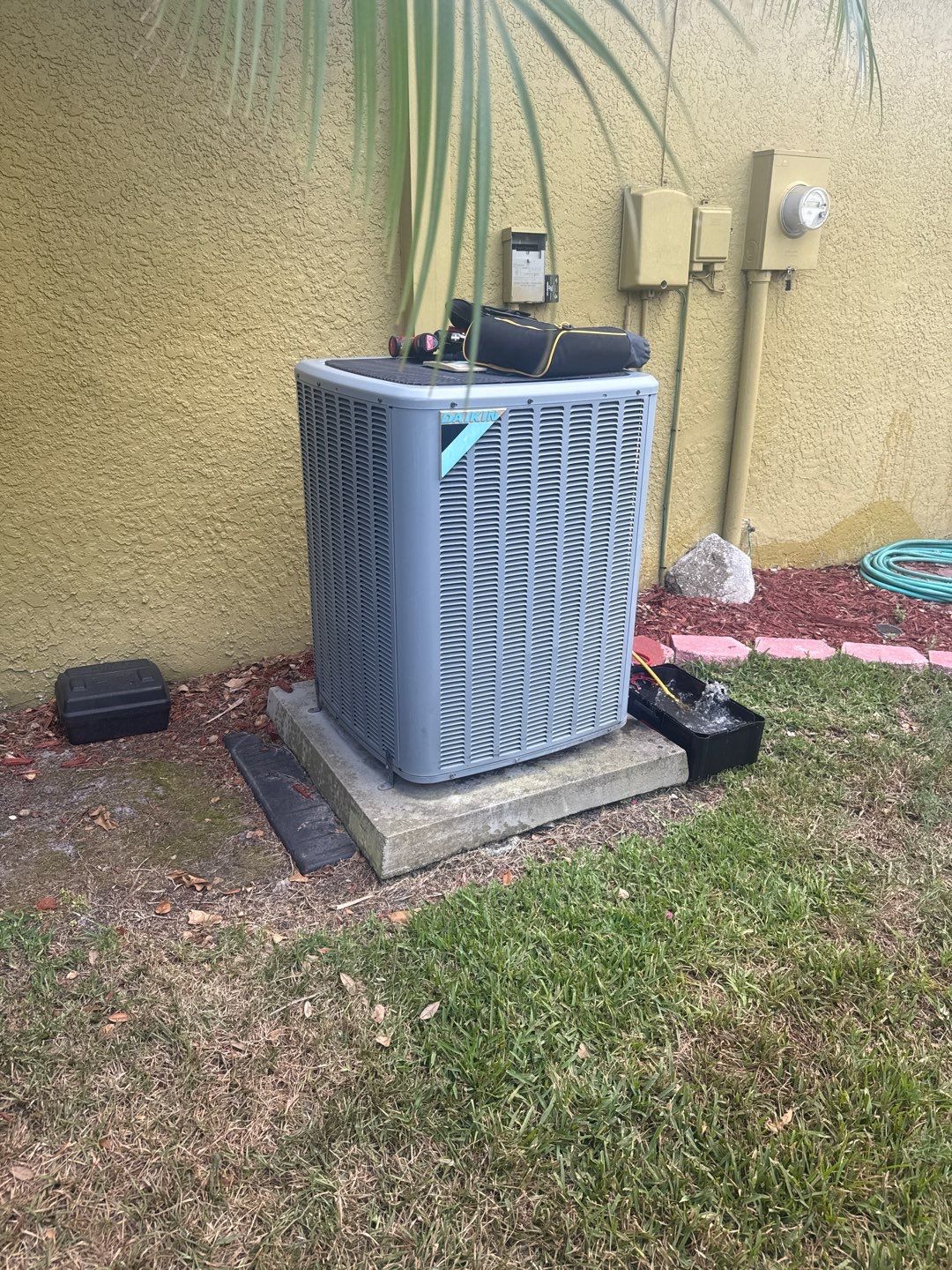 Old outdoor unit beside a Land O' Lakes home before replacement