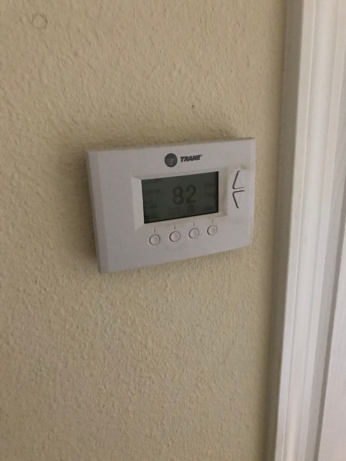 Old thermostat on the wall before replacement in Land O' Lakes, FL