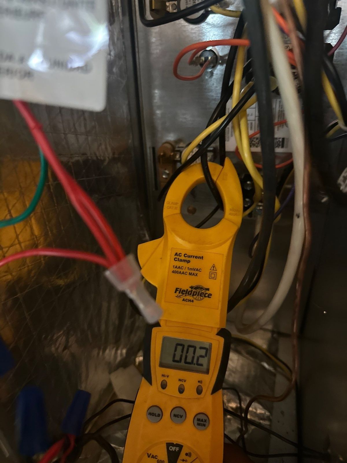 Clamp meter checking amp draw on a new air handler