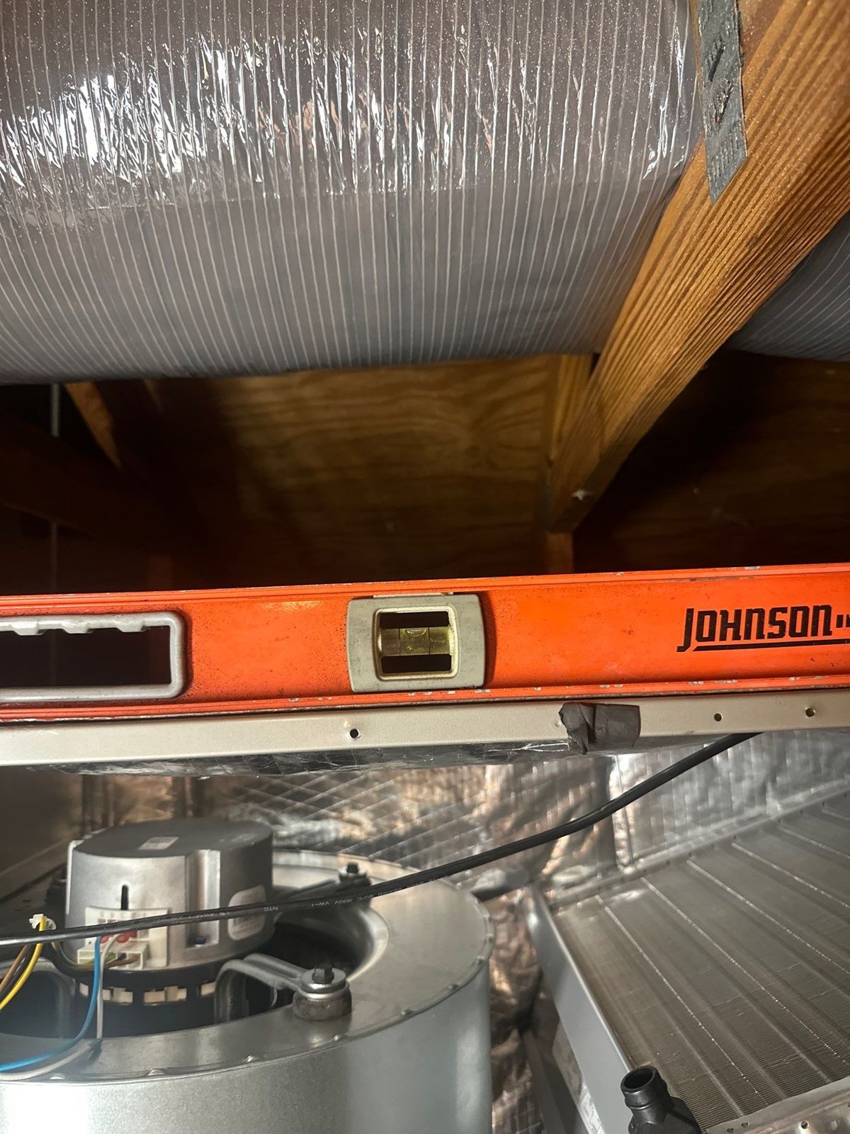 Level set across a new air handler during installation in an attic