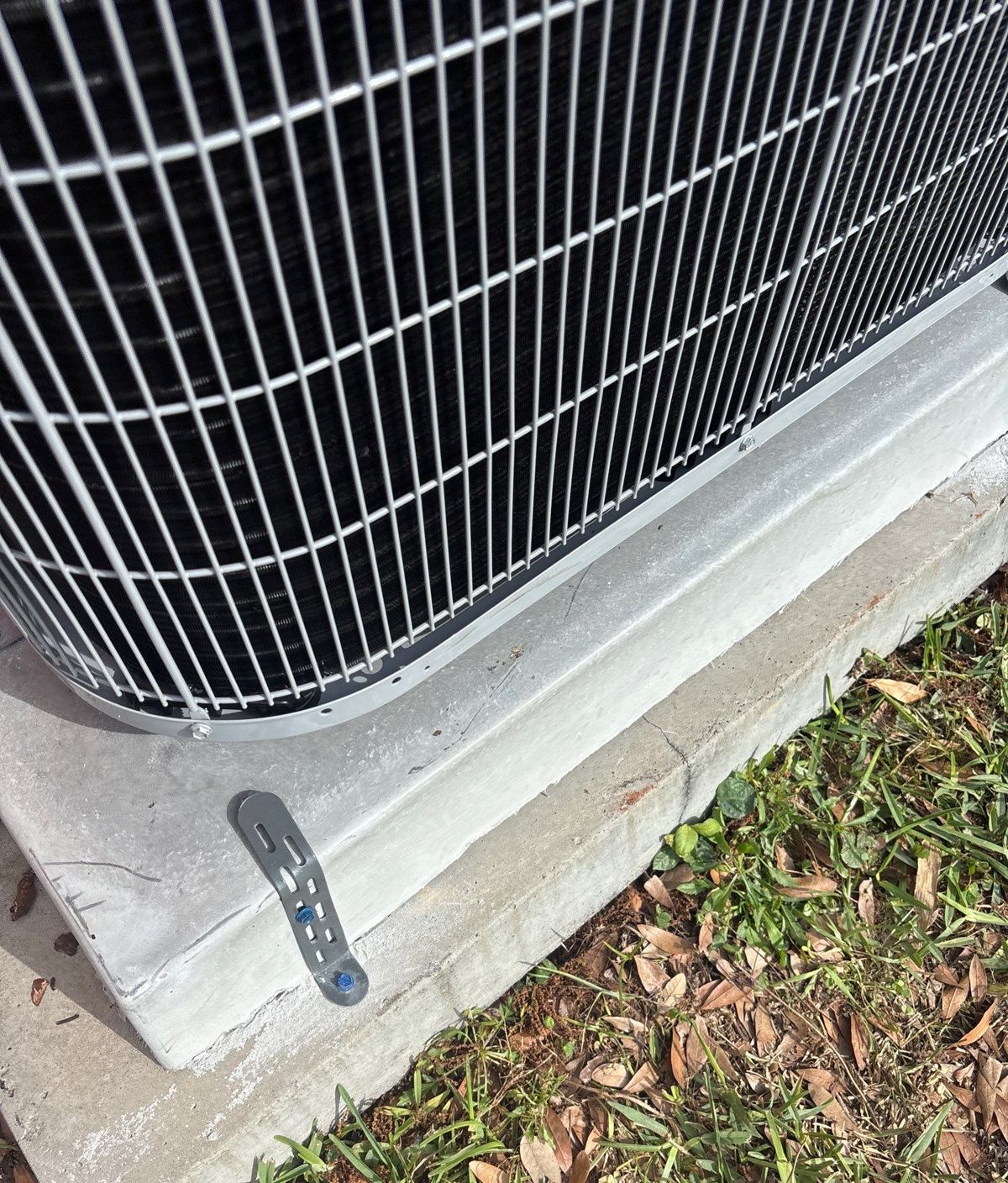 New heat pump outdoor unit strapped down on a hurricane pad in Tampa, FL